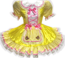 Yellow dress with pink ribbon bows and teddy bear appliques on a white background
