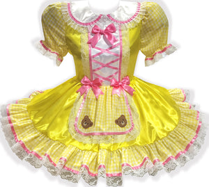 Yellow dress with pink ribbon bows and teddy bear appliques on a white background
