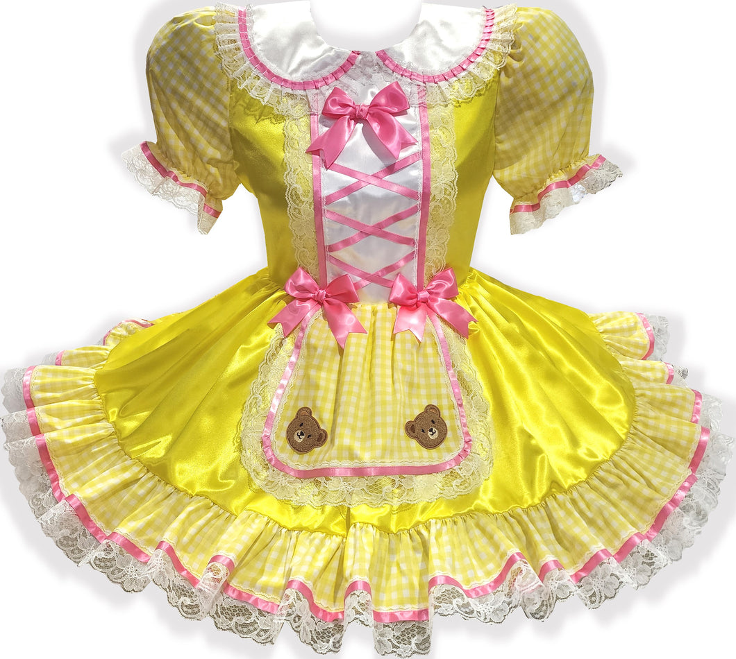 Yellow dress with pink ribbon bows and teddy bear appliques on a white background