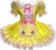 Yellow dress with pink ribbon bows and teddy bear appliques on a white background