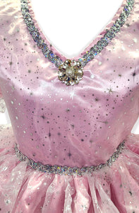 Close-up of a pink dress with sparkling embellishments on a light pink background