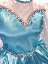 Close-up of a aqua satin dress with decorative trim 