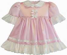 Pink and white dress with ruffled details on a white background