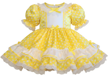 Yellow polka dot dress with white accents on a white background