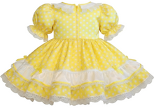 Yellow polka dot dress with white lace trim on a white background