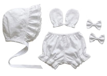 An adult baby bonnet with a long ribbon, a pair of mittens, a pair of bloomers, and two small hair bows