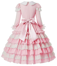 A pink long-sleeve Lolita-style dress with white lace trim and a large satin bow at the back waist, shown on a mannequin against a plain white background.