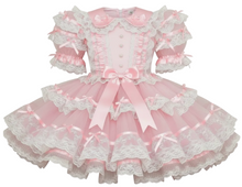 Pink sheer dress with lace and bows on a white background