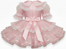 Pink lace dress with ruffles and a bow on a white background