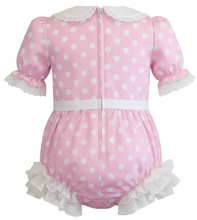 Pink polka dot adult romper with white lace details on a white background