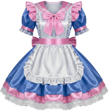 A blue and pink short-sleeve dress with a white apron overlay, ruffled collar, and large pink bow details, shown on a plain light gray background.