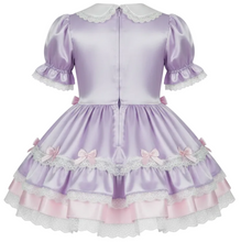 A lavender short-sleeve Lolita-style dress with a white Peter Pan collar, ruffled sleeves, a tiered skirt with pink bows and lace trim, and a pink underlayer visible at the hem, shown against a plain white background.