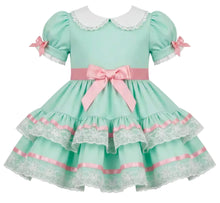 A mint green and pink adult toddler style girl's dress with a white Peter Pan collar, puffed sleeves with lace trim, a pink waistband with a large bow, and a tiered skirt with lace and satin ribbon details.