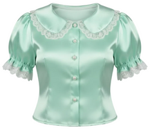 A mint green satin short-sleeve blouse with white lace trim, pearl buttons, and white lace bows on the collar, shown against a plain white background.