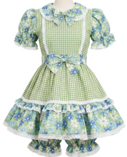 Green checkered dress with floral patterns on a mannequin against a white background