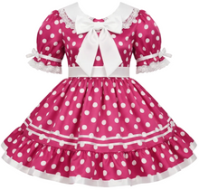 A pink and white polka dot sissy dress featuring short puff sleeves with lace trim, a large white bow at the collar, a white waistband, and a tiered ruffled skirt.