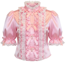 A pink satin blouse with ruffles, lace trim, and bow details, shown against a plain white background.