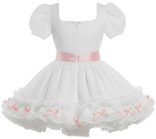 A white Lolita-style dress with short puff sleeves, a sweetheart neckline, a pink satin waistband, and a layered ruffled skirt decorated with lace and small pink bows, shown against a plain white background.