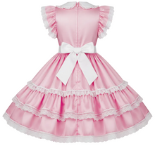 A pink Lolita-style dress with white lace trim, ruffled cap sleeves, a large white bow at the waist, and a tiered skirt, shown against a plain white background.