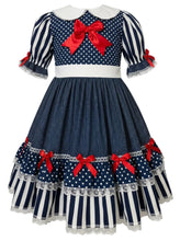 A navy blue and white polka dot and striped dress with red bows, featuring a white Peter Pan collar and short puff sleeves with lace trim.