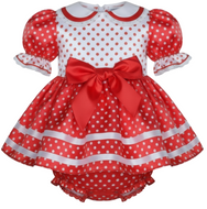 Red and white polka dot baby dress with a large bow on a white background