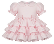 Pink dress with ruffled layers on a white background