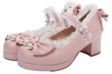 A pair of pastel pink Lolita-style platform block-heel shoes with white ruffled trim, bows, and pearl embellishments on the toes, shown against a plain white background.