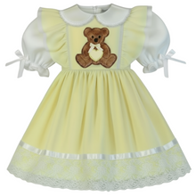 Yellow dress with a teddy bear design on a white background