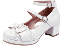 A white faux-leather Mary Jane block heel shoe with a lace-trimmed toe, a matching fabric bow, and adjustable ankle straps with silver buckles, shown against a plain white background.